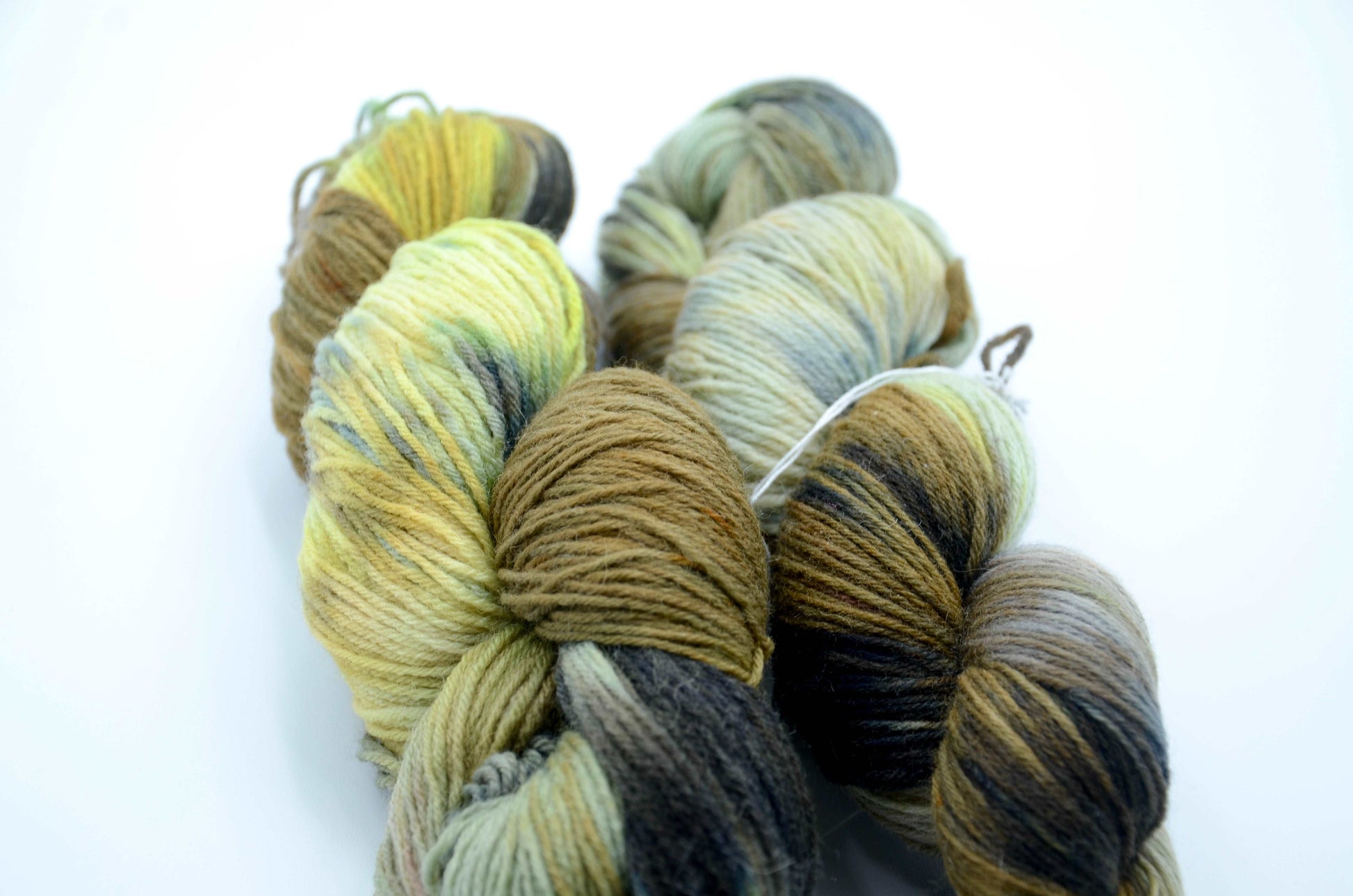 hand painted and hand dyed knitting yarn with notes of dark olive green, bright yellow and gray