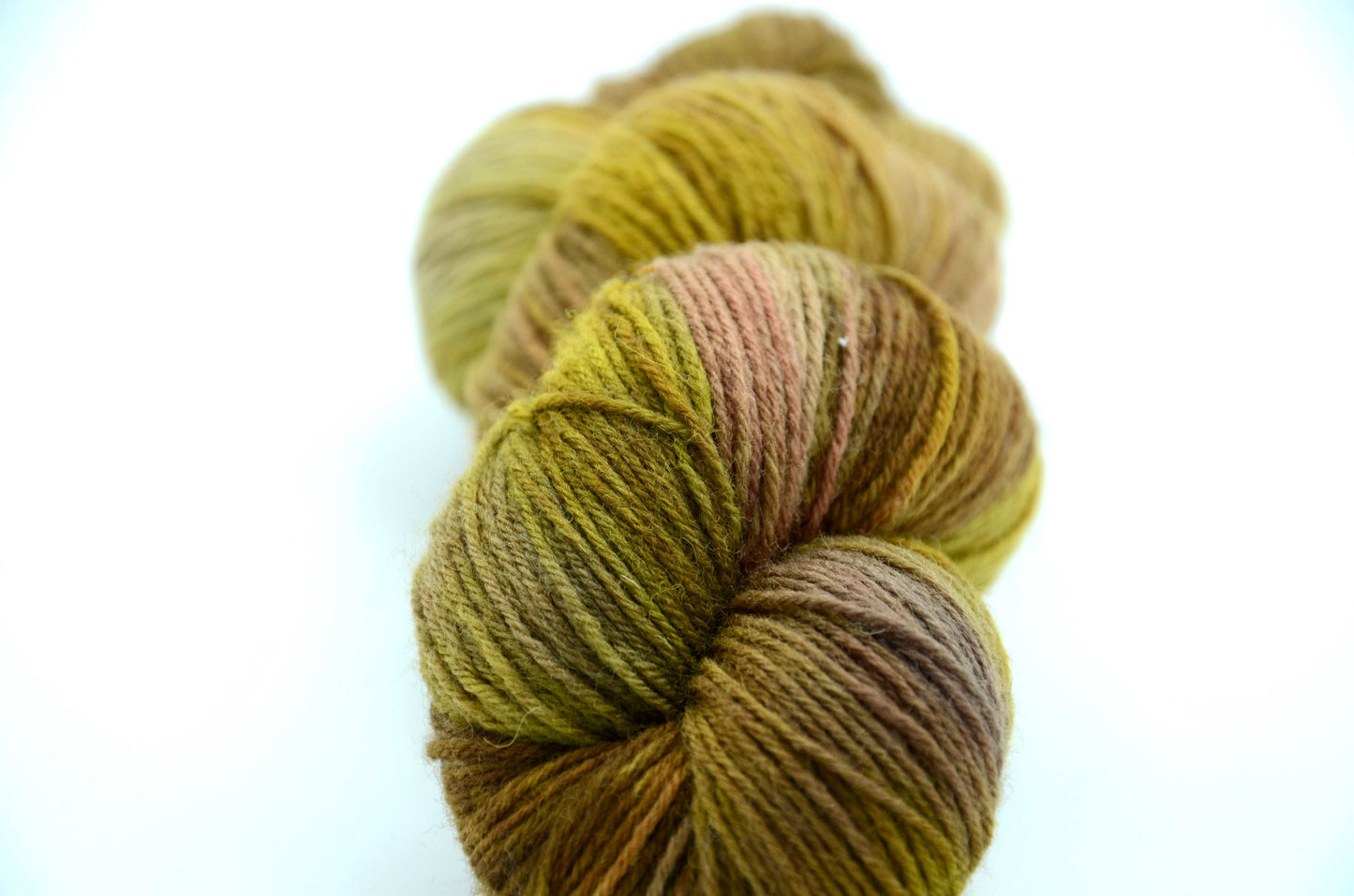 golden green hand painted and hand dyed knitting yarn with notes of brown, coral and beige