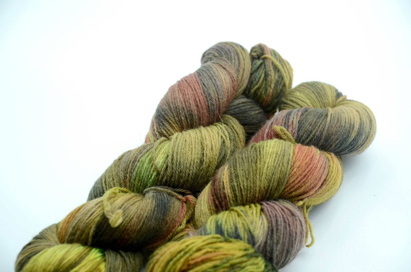 sage green hand dyed and hand painted knitting yarn with notes of orange and dark army green