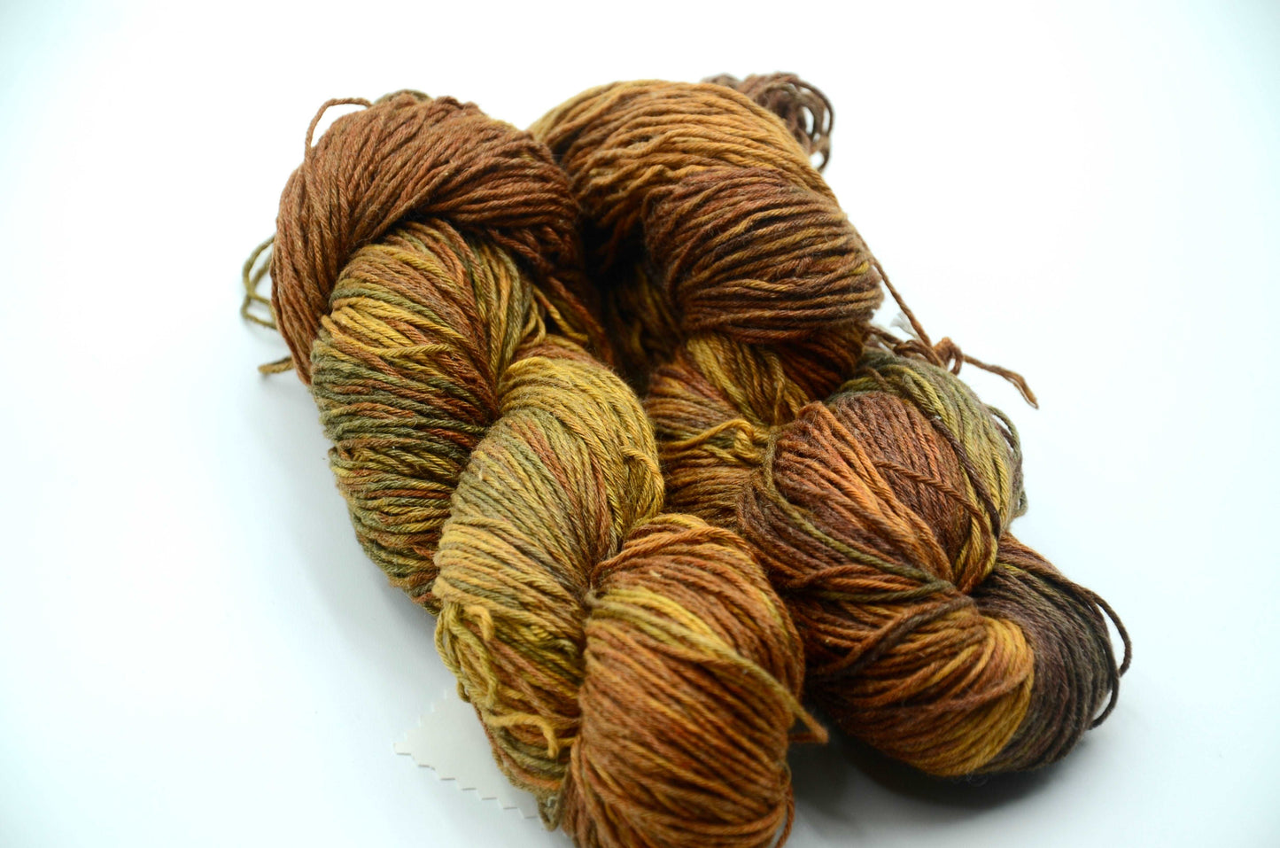 warm toned hand dyed and hand painted knitting yarn with notes of golden yellow and warm brown