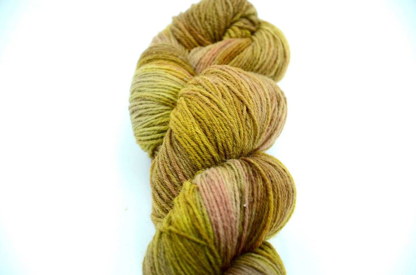 golden green hand painted and hand dyed knitting yarn with notes of brown, coral and beige