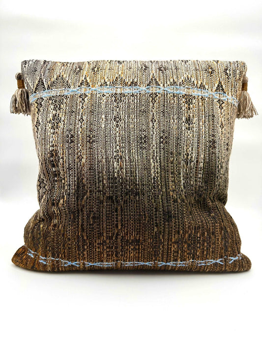 Neutral Brown toned handwoven pillow cover with light blue details and tassels in the corners