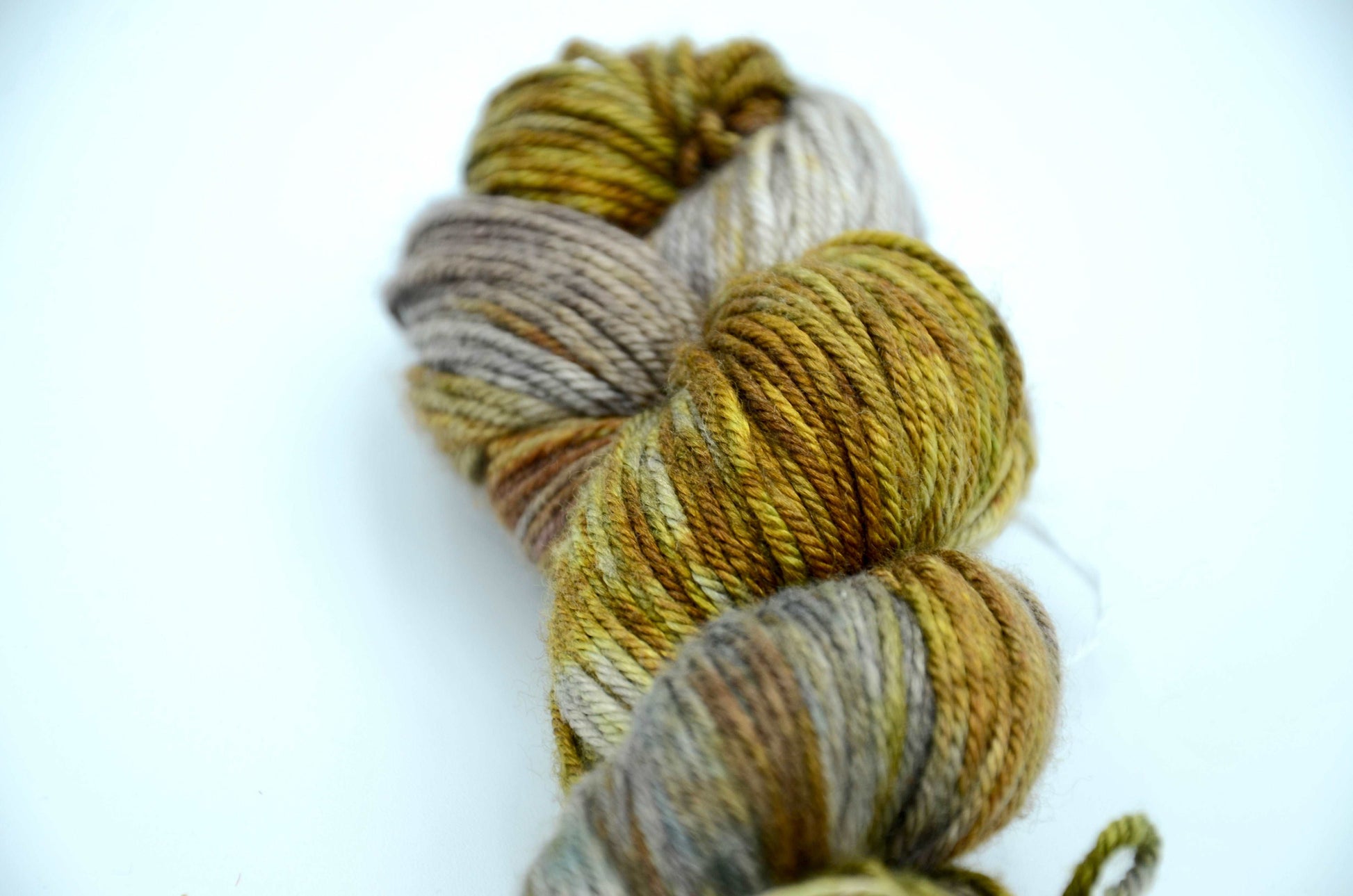 hand dyed and hand painted knitting yarn tones of light green and gold