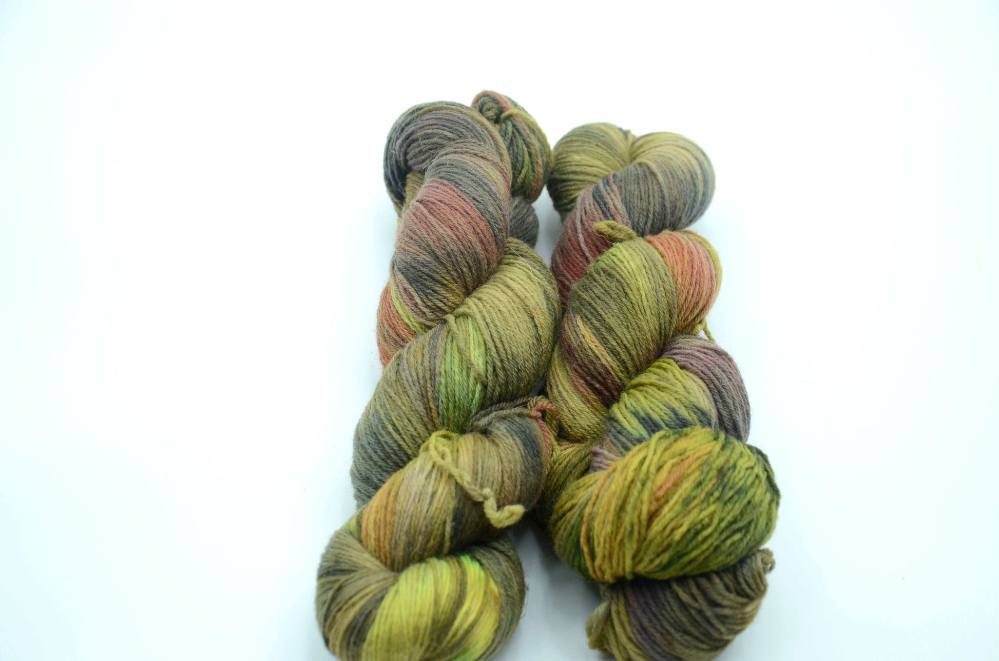 sage green hand dyed and hand painted knitting yarn with notes of orange and dark army green