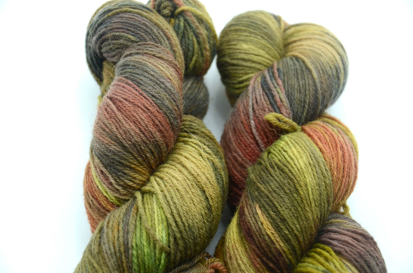 sage green hand dyed and hand painted knitting yarn with notes of orange and dark army green