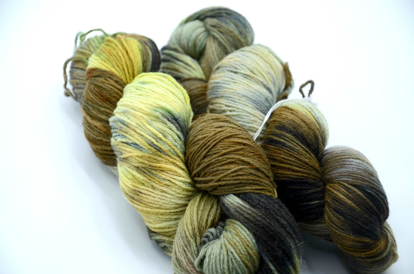 hand painted and hand dyed knitting yarn with notes of dark olive green, bright yellow and gray