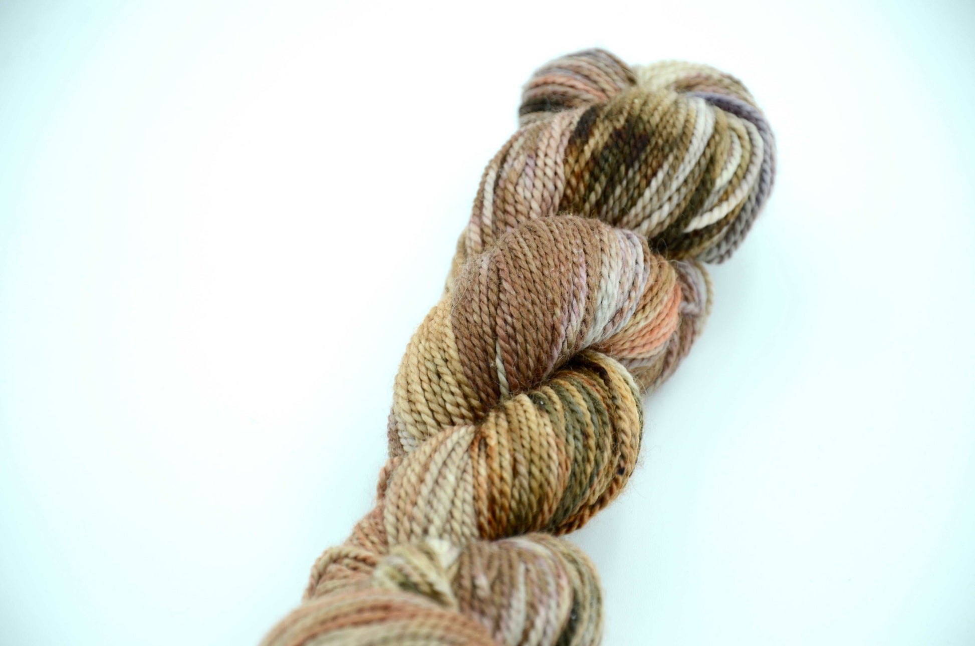 neutral toned hand painted and hand dyed knitting yarn with coral notes