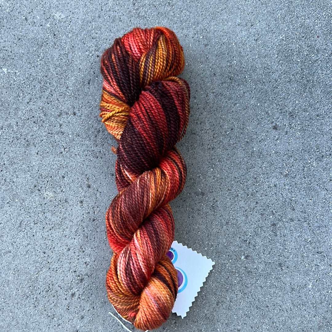 hand dyed and hand painted knitting yarn with notes of pink, orange and dark red