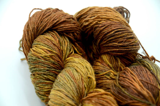 warm toned hand dyed and hand painted knitting yarn with notes of golden yellow and warm brown