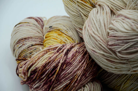 neutral toned hand dyed and hand painted knitting yarn with speckles of yellow and burgandy