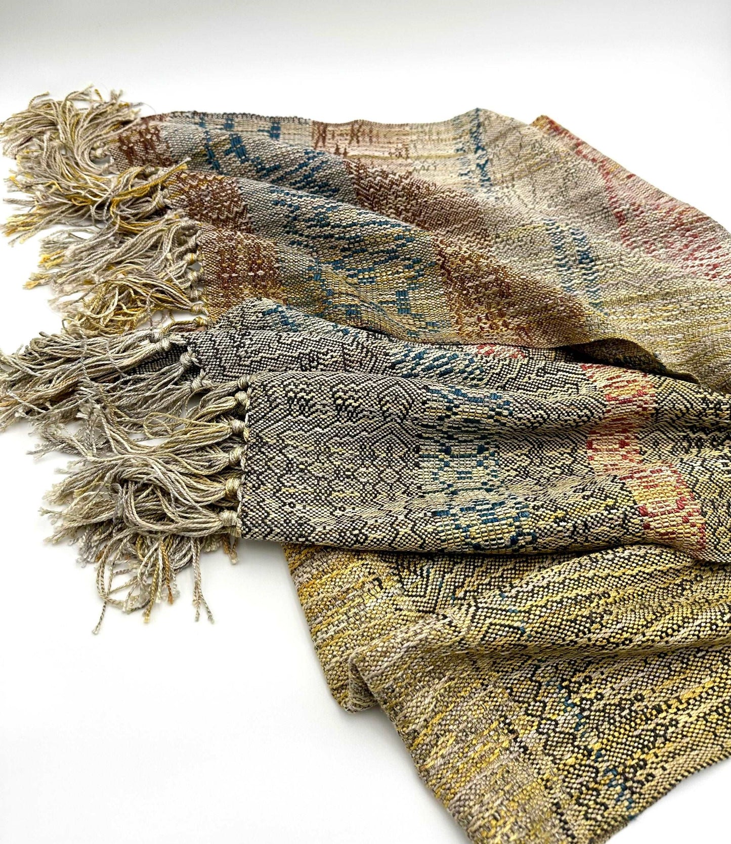 neutral colored womens handwoven scarf with notes of blue, red and yellow