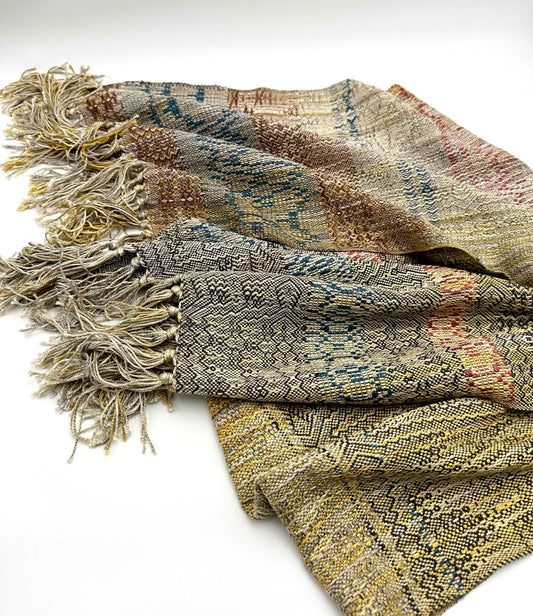 neutral colored womens handwoven scarf with notes of blue, red and yellow