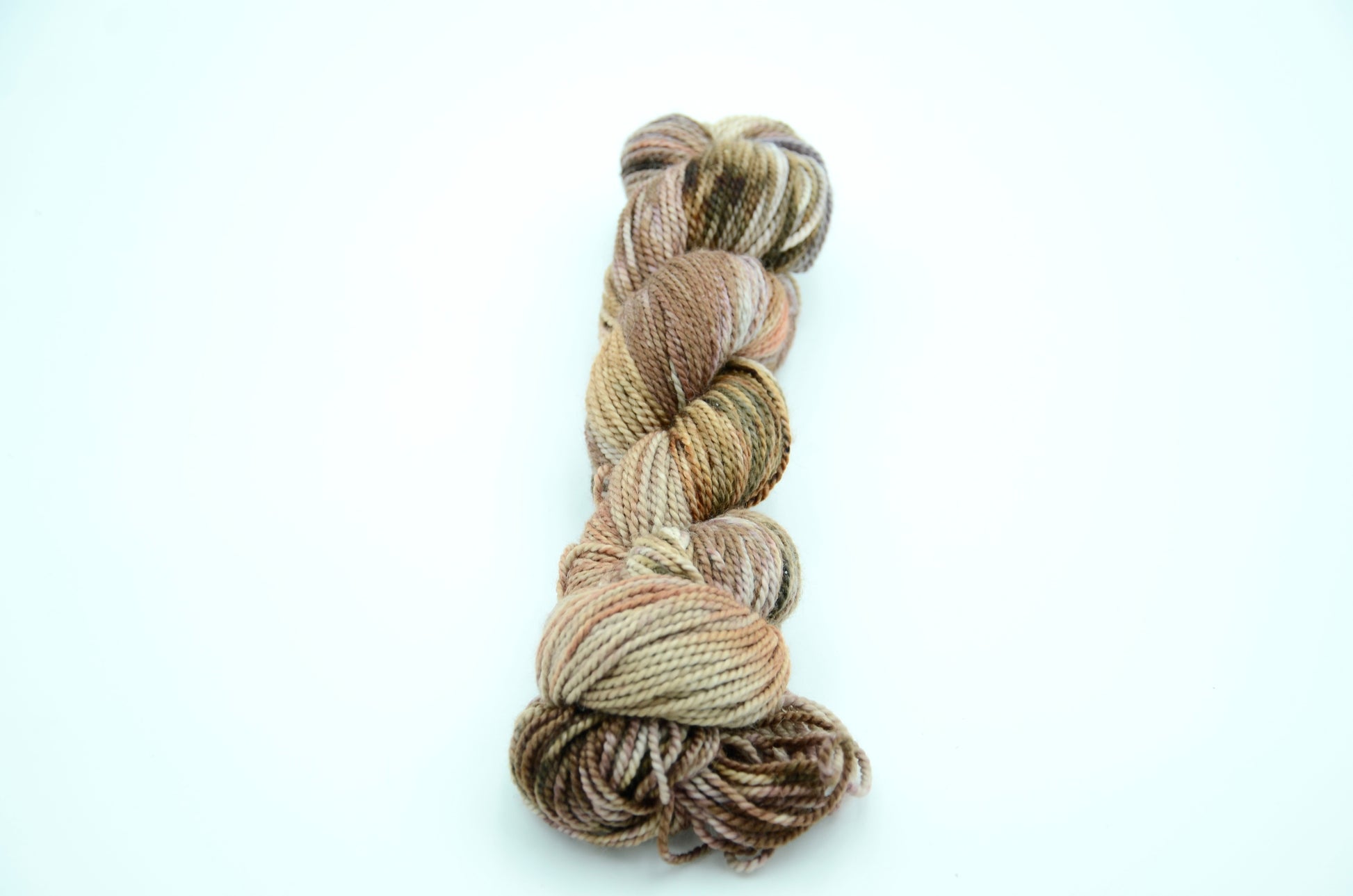 neutral toned hand painted and hand dyed knitting yarn with coral notes