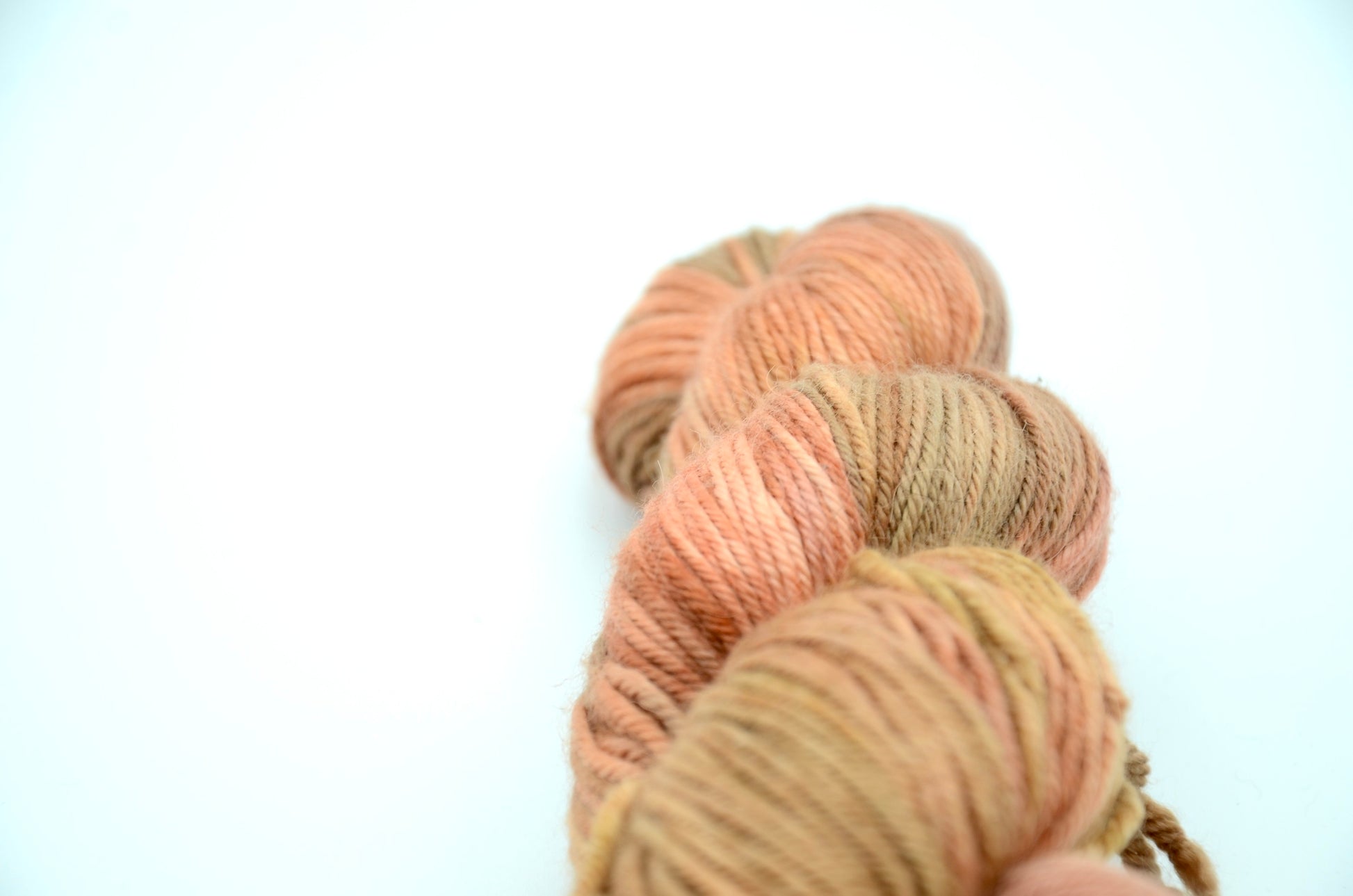 Coral colored hand painted and hand dyed knitting yarn with beige tones